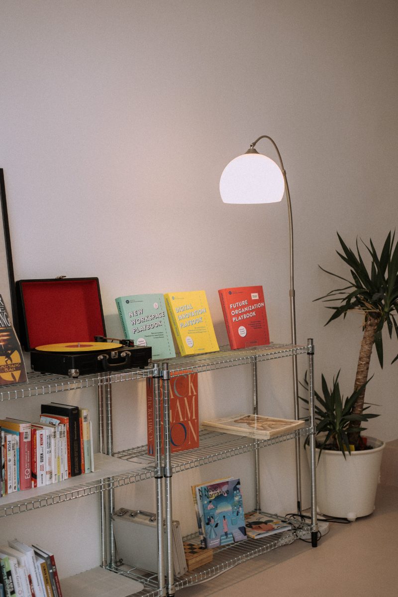 Regal mit Playbooks, Bogenlampe und Yucca